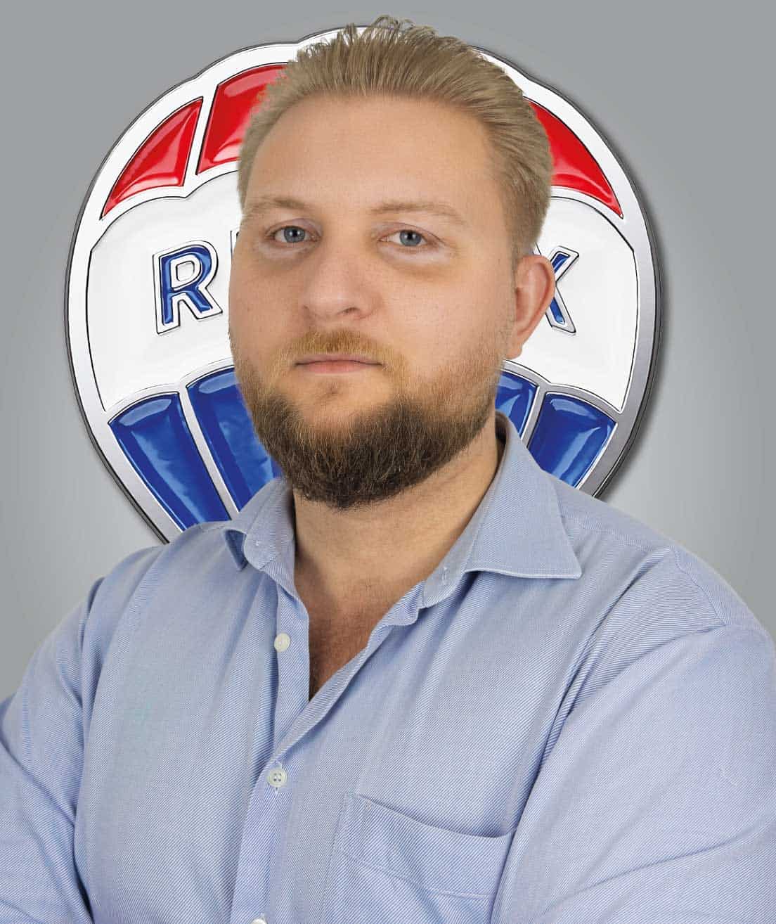 Agente imobiliário Grupo RE/MAX Select com logotipo ao fundo.